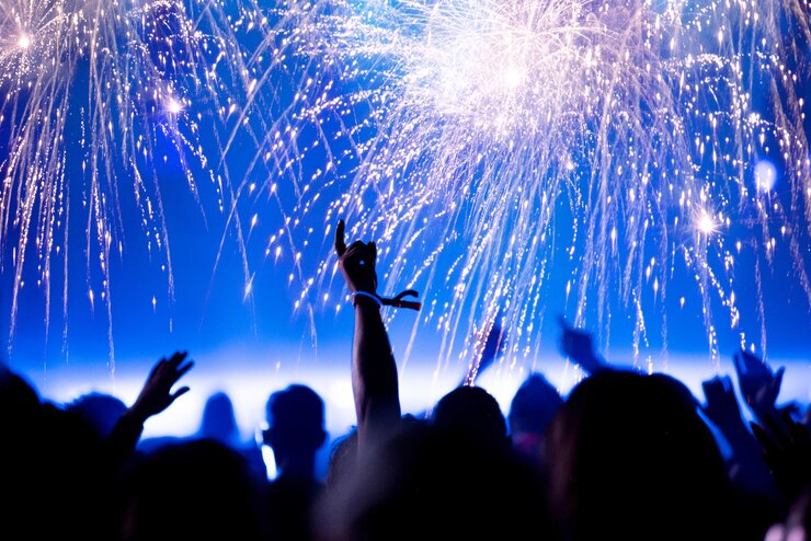 फोटो silhouette people at music festival against firework at night