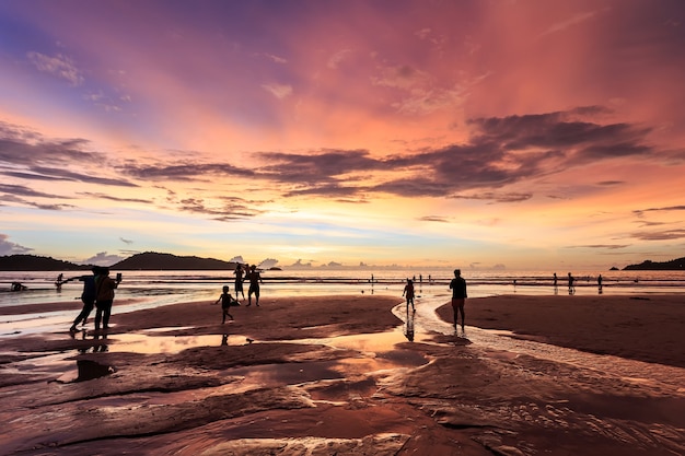 Silhouette of people playing on the beach at sunset