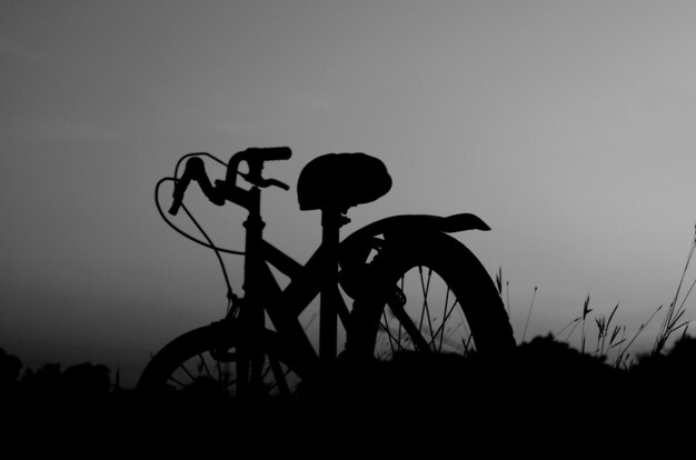 Photo silhouette people riding bicycle against sky during sunset