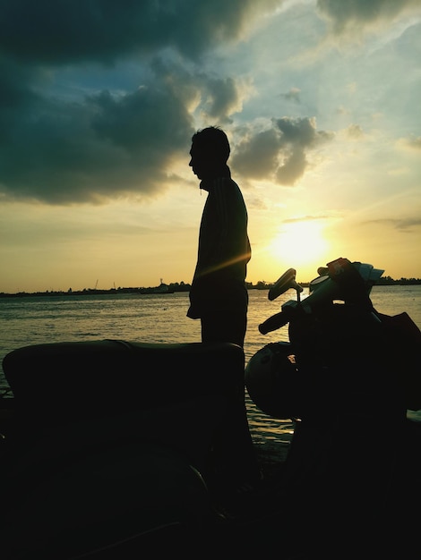 Silhouette of people in sea at sunset