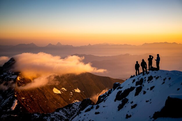 Photo silhouette people on snowcapped mountain against sky during sunrise