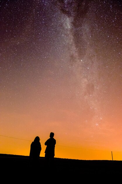 夜空に立っている人々のシルエット