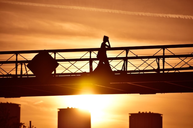 Photo silhouette people standing on bridge against sky during sunset