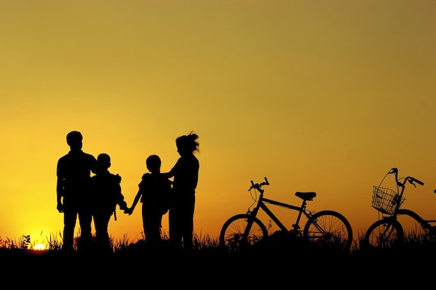 silhouette people standing on field against sky during sunset