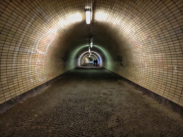 Photo silhouette of people walking inside tunnel