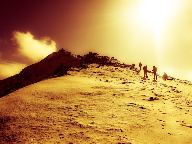 Foto silhouette di persone che camminano su un paesaggio coperto di neve