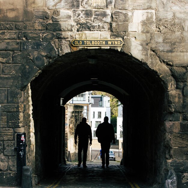 Foto silhouette di persone che camminano nel tunnel