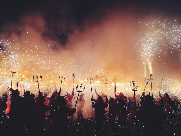 伝統的な祭りで花火を放つ人々のシルエット