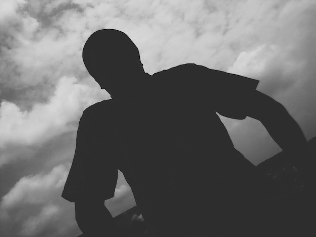 Photo silhouette of person against cloudy sky