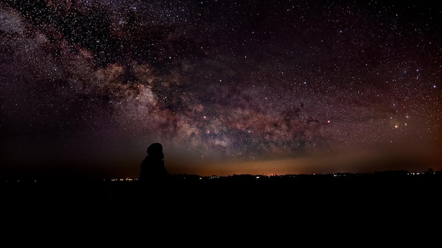 夜の空を背景に描かれた人物のシルエット