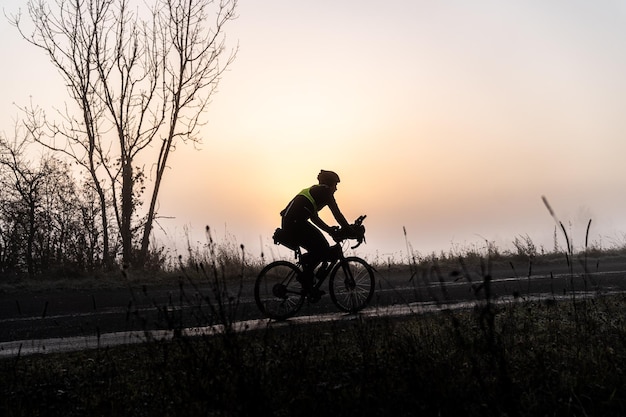 Photo silhouette person cycling on road against sky