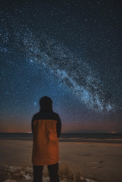 A silhouette of a person in front of a universe constellation
concept of outdoors night skies and milky way observation