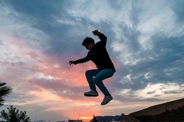 Foto silhouette di una persona che salta all'aperto con il cielo al tramonto sullo sfondo