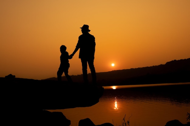 Silhouette of a person on a rock near the reservoir