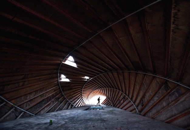 Photo silhouette person standing at the end of tunnel