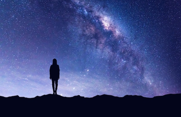 Silhouette person standing on field against star field
