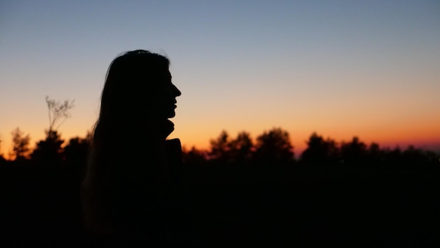 Silhouette of a person at sunset young woman girl teenager in profile close up