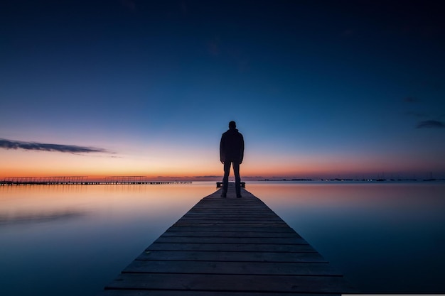 Photo silhouette of person walking on the beach