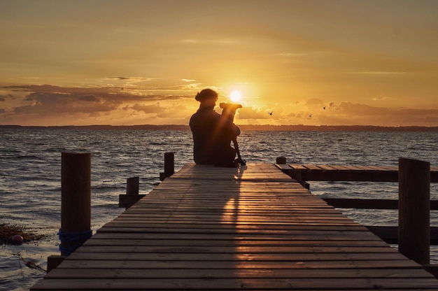 silhouette of a person walking on the pier