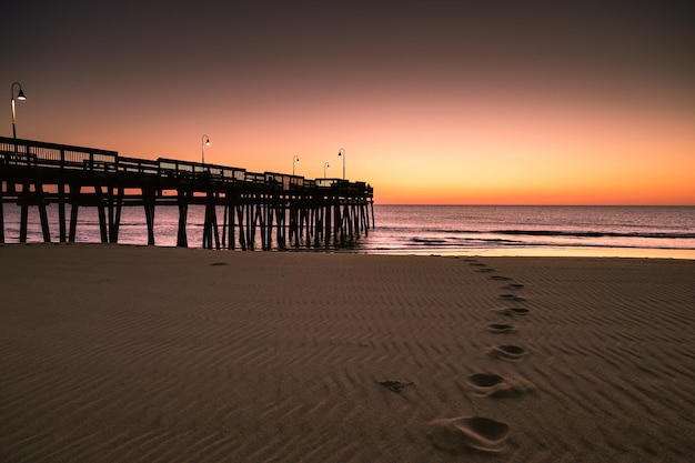 Foto silhouette pier sulla spiaggia contro il cielo durante il tramonto