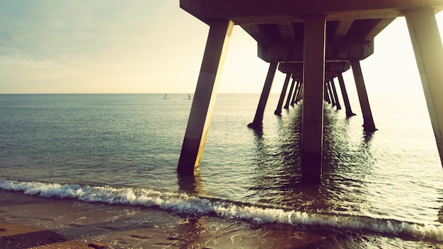 Foto silhouette pier sulla spiaggia contro il cielo