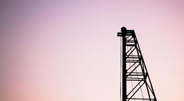 Silhouette pile driver at construction site