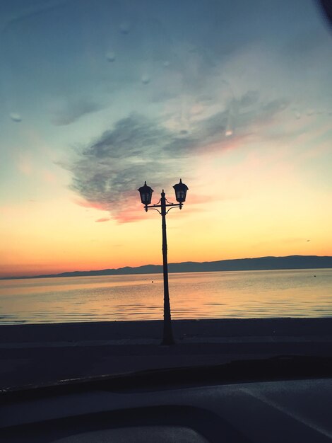 Foto silhouette pole sulla spiaggia contro il cielo durante il tramonto
