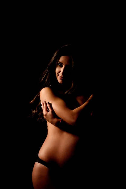 Silhouette of pregnant woman in the dark