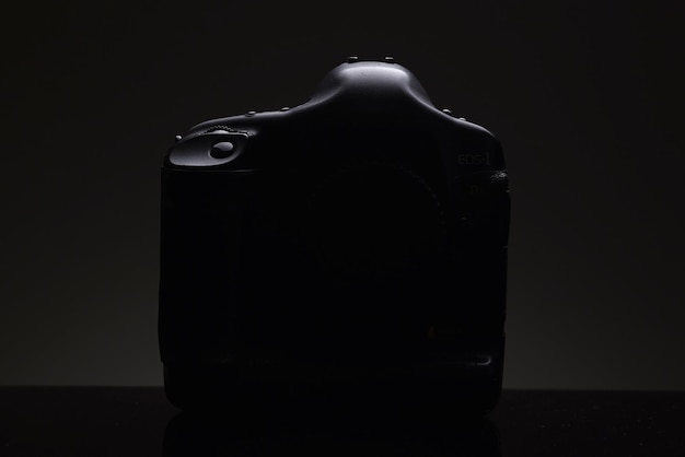 The silhouette of a professional SLR camera on a black background Presentation of a new product