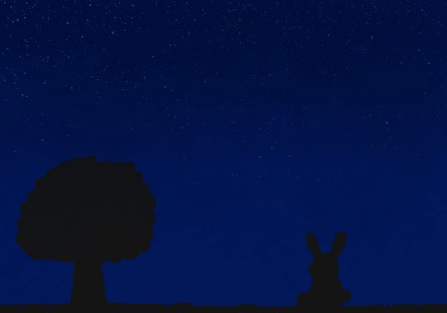 Silhouette di un coniglio e un albero di notte il cielo è blu