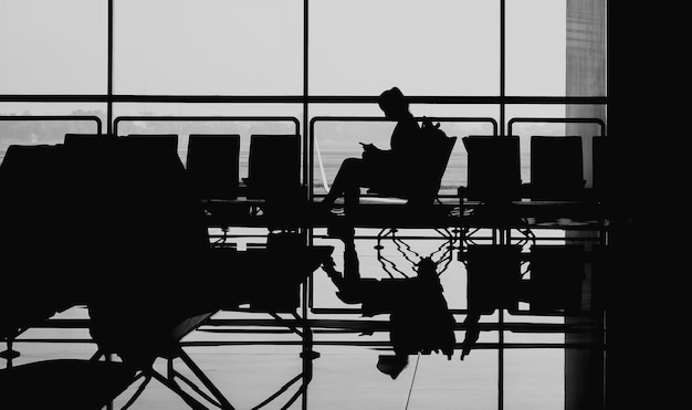 Photo silhouette reflection tourists are traveling by plane. black and white style.