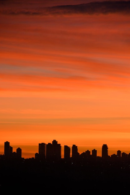 Photo silhouette of residential buildings on sunset sky background