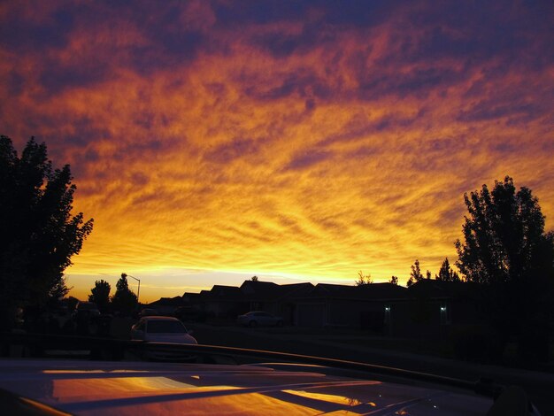 Silhouette road against orange sky