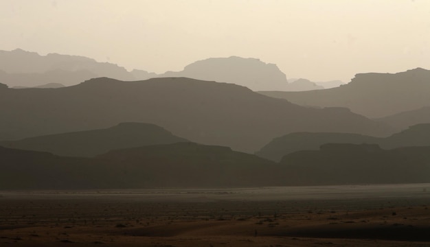 Photo silhouette rocky mountains in foggy weather