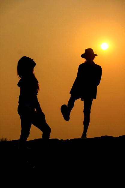 Photo silhouette romantic couple standing against sky during sunset