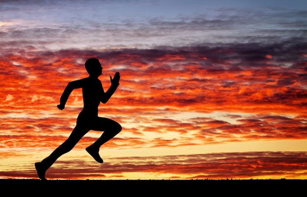 Silhouette of running man on sunset fiery background