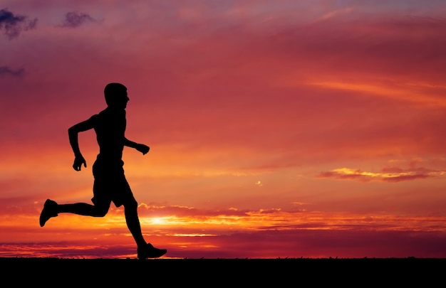 Silhouette of running on sunset fiery background