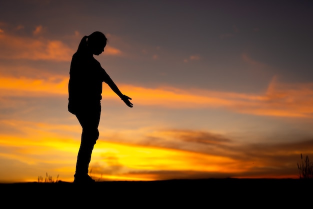 Silhouette di donne tristi e depresse che camminano sulla passerella del parco con il tramonto