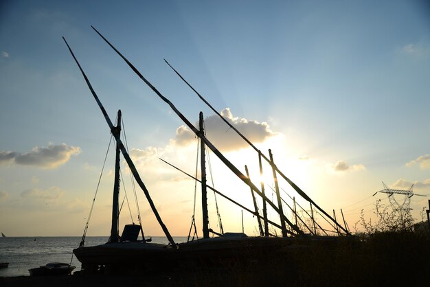 Silhouette sailboat on sea against sky during sunset