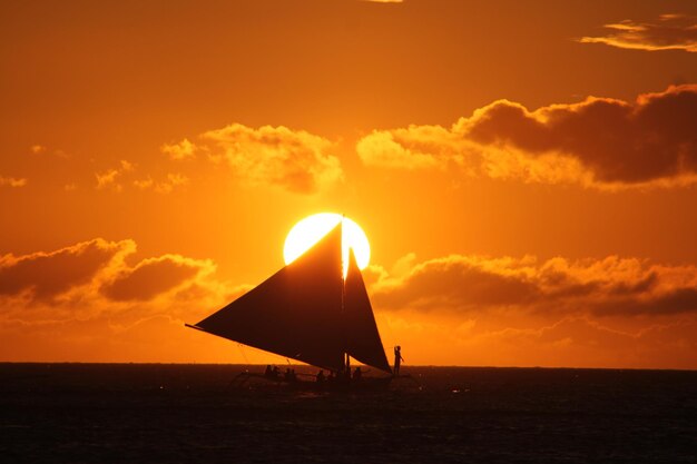 夕暮れの海中の帆船のシルエット