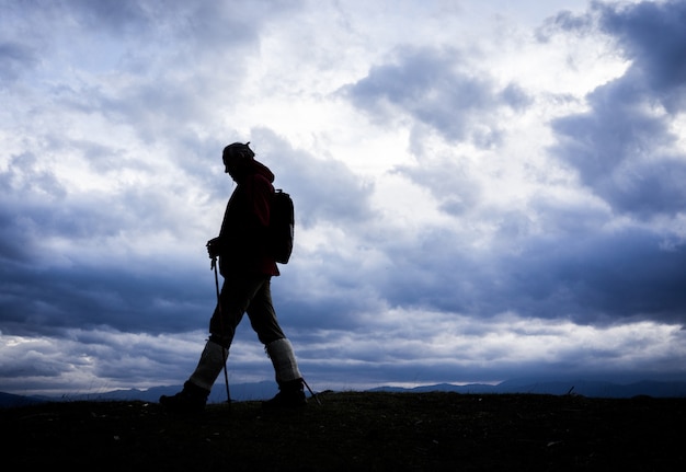 Silhouette of senior woman hiking in nature