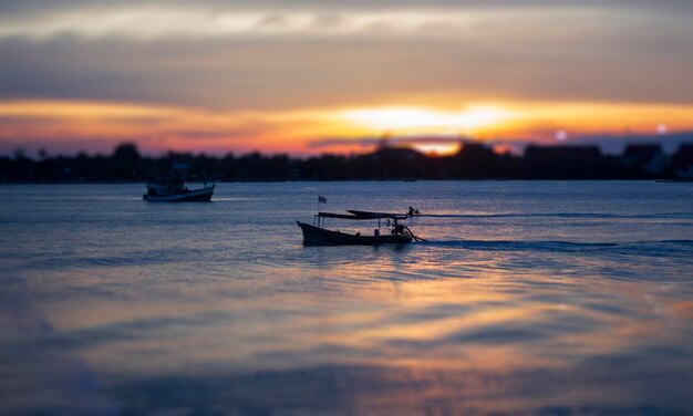 Silhouette ship in sea against sky during sunset