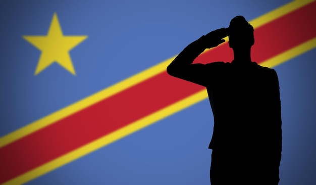 コンゴ民主共和国の旗に敬礼する兵士のシルエット