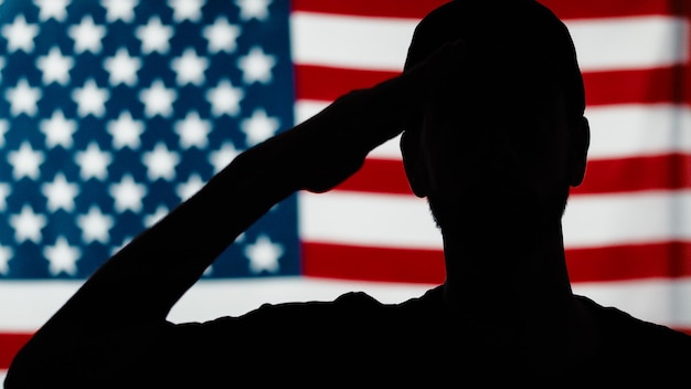 Photo silhouette of soldier saluting close up