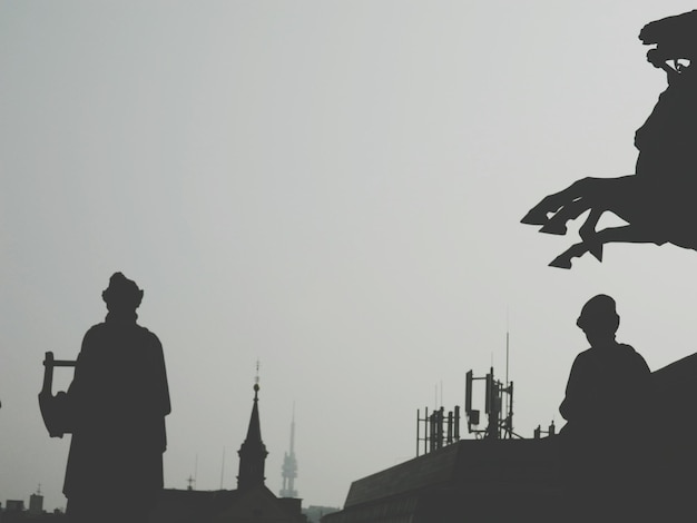 Silhouette statue against clear sky during sunset