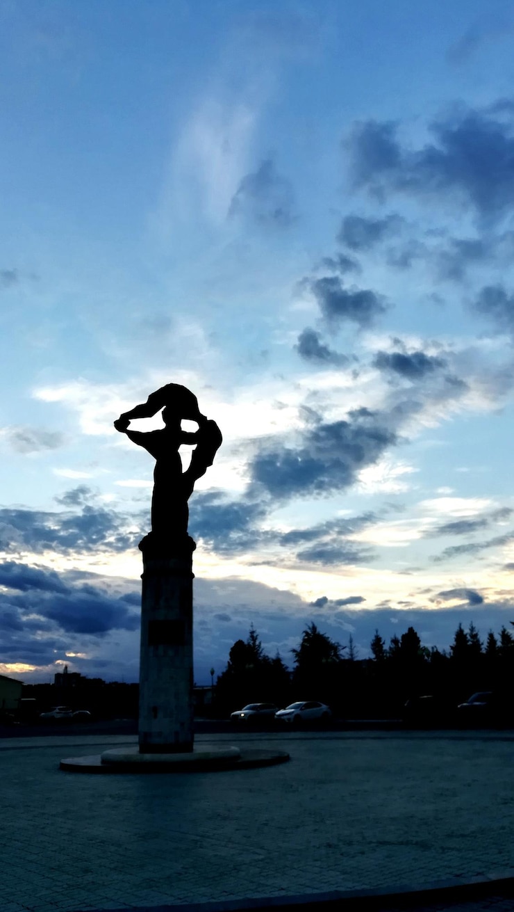 Photo silhouette statue by tree against sky