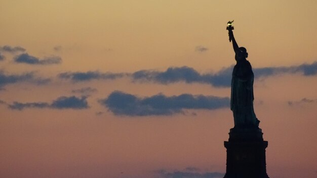 写真 夕暮れの空に映る自由の像のシルエット