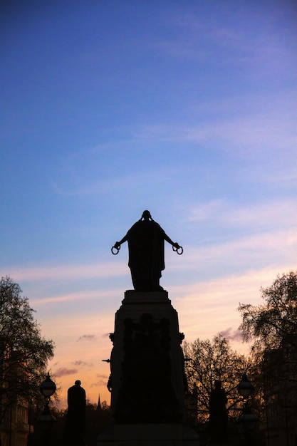 Foto statua a silhouette a trafalgar square durante il tramonto