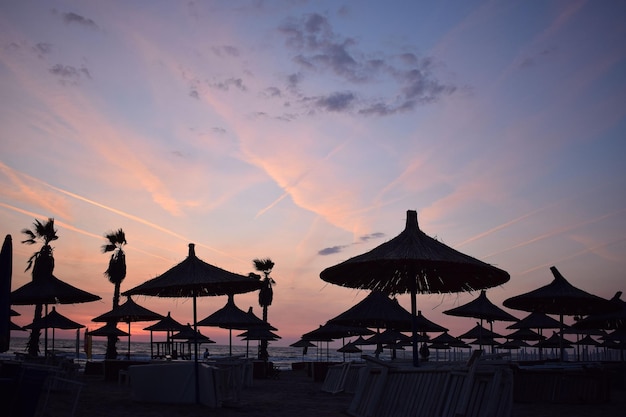 Silhouette of straw umbrellas at sunset on the beach