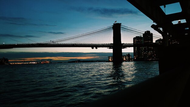 Photo silhouette of suspension bridge over sea